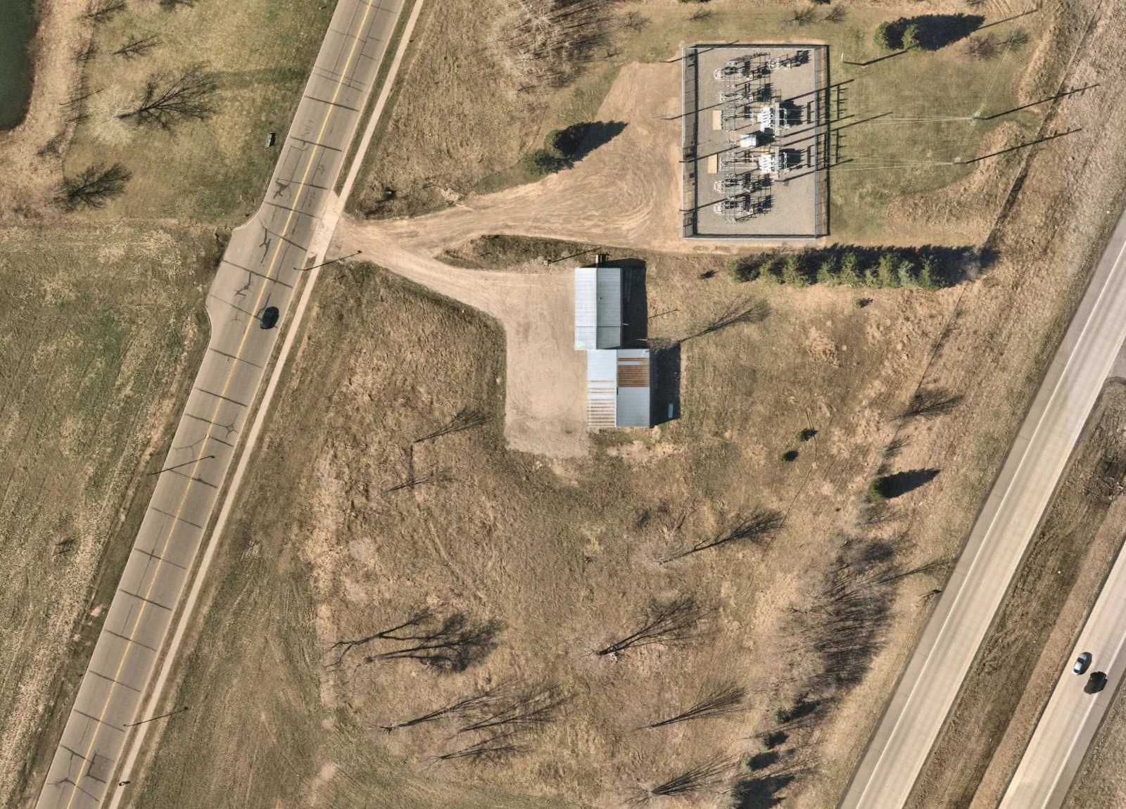 North-up aerial of the existing two-wing building, with Garfield Street on the west and Highway 65 on the east. The neighboring substation is outside the subject site.
